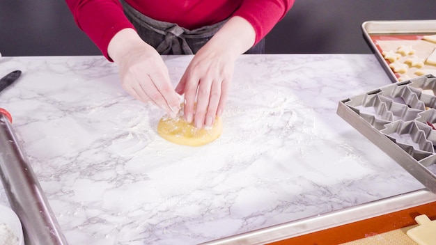 Estirando masa de galleta de azúcar para hornear galletas navideñas.