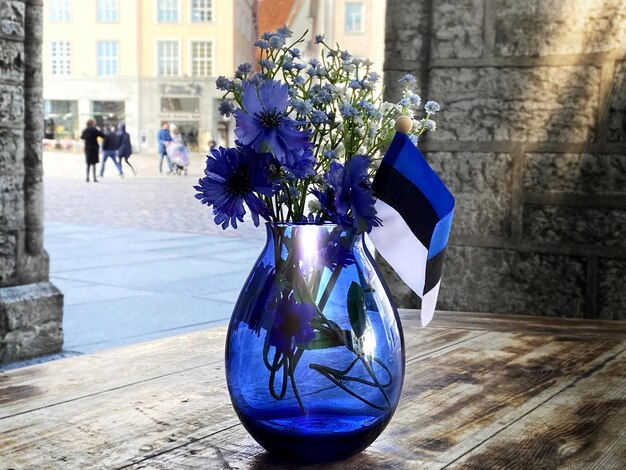 Estnische Flagge im blauen Glas auf dem Tisch im Straßencafé auf dem alten Rathausplatz von Tallinn