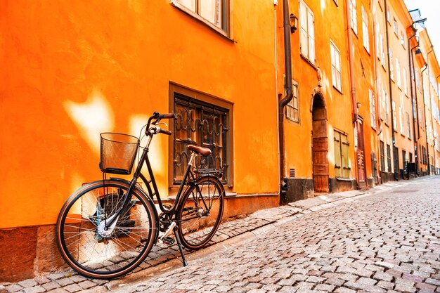 Estocolmo, Suiza. Bicicleta en la calle cerca de la pared naranja de la casa.