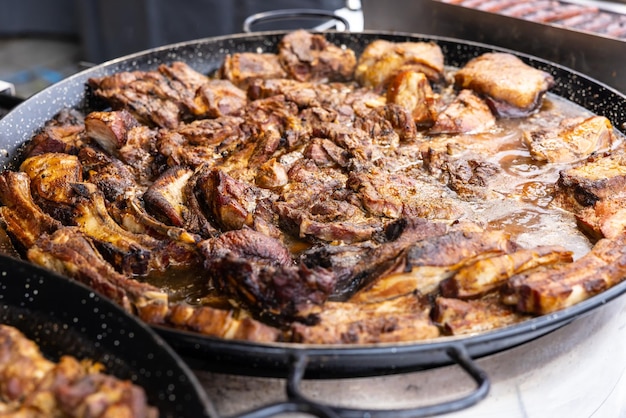 Estofado de carne con carne de cerdo y cordero en una salsa jugosa burbujeando en una sartén grande en el mercado callejero