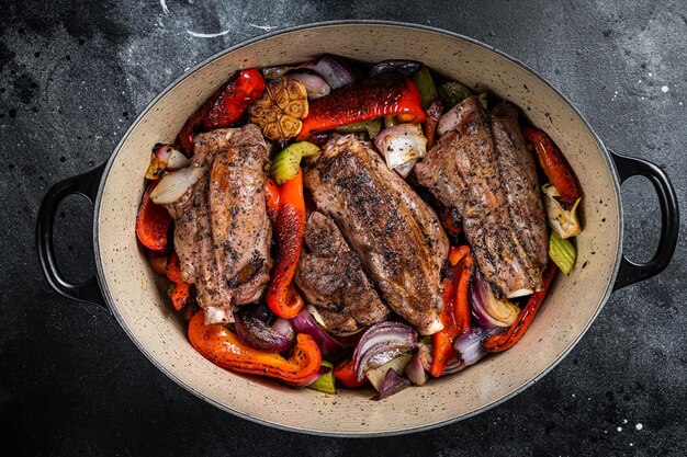 Estofado de cordero cocido a fuego lento en salsa de vino tinto con verduras en una olla Fondo negro Vista superior