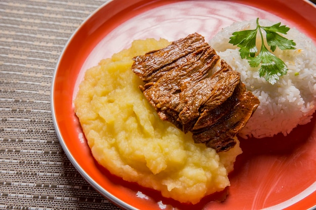 Estofado de res puré de papas arroz comida reconfortante tradicional cocina peruana gastronomía