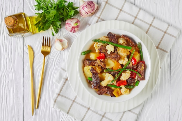 Estofado de tiras de ternera con patatas nuevas, espárragos y coliflor