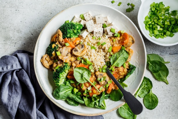 Foto estofado vegano de lentejas con champiñones, quinua, espinacas y brócoli en un tazón, vista desde arriba. concepto de comida vegana saludable.