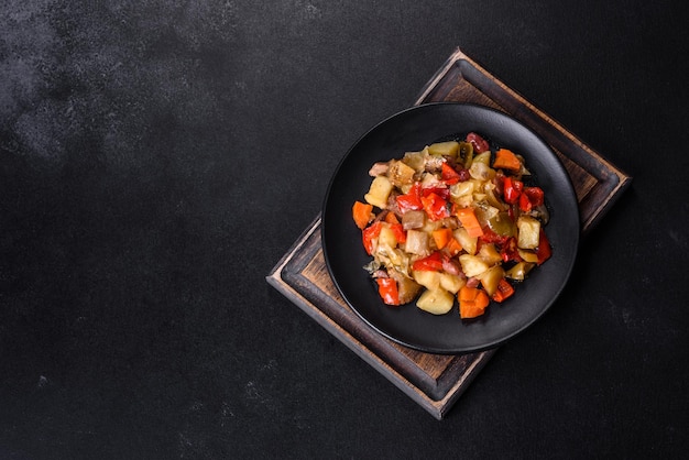 Estofado de verduras o ratatouille con berenjenas, tomates, pimientos dulces y picantes, cebollas, zanahorias y especias en un plato