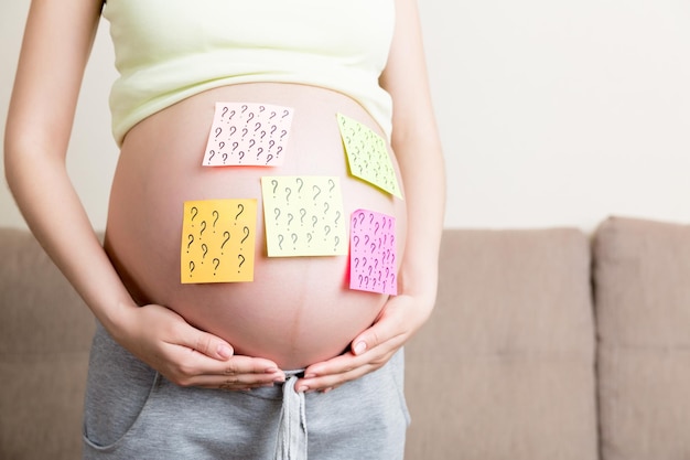 Estómago de mujer embarazada con signo de interrogación Embarazo y problema de pensamiento