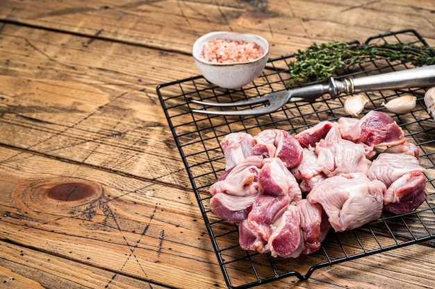 Estómagos de pollo crudo fresco mollejas en una parrilla lista para cocinar con hierbas Fondo de madera Vista superior Espacio de copia