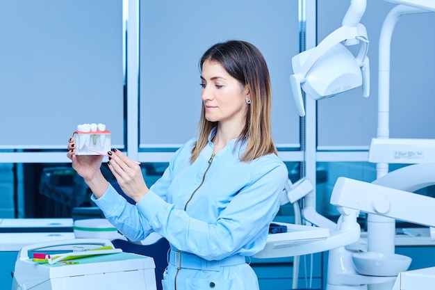 Estomatologia de medicina de pessoas e conceito de saúde feliz jovem dentista feminina com ferramentas sobre fundo de consultório médico