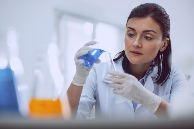 Estou inspirado. Alertar pesquisador de cabelos escuros que realiza um teste enquanto trabalha no laboratório