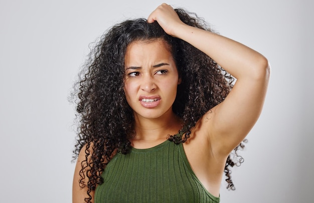 Foto estou sem ideias sobre o que fazer com meu cabelo foto de uma mulher com cabelo encaracolado franzindo a testa contra um fundo cinza