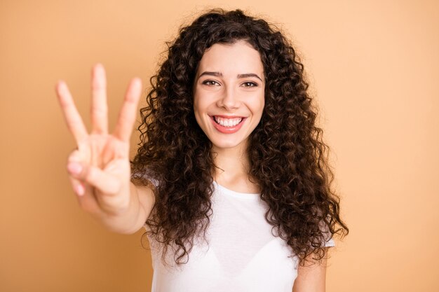 ¡Estoy contando hasta tres! Foto en primer plano de la señora divertida levantando la mano mostrando tres dedos ropa de humor positivo traje casual blanco aislado fondo de color beige pastel