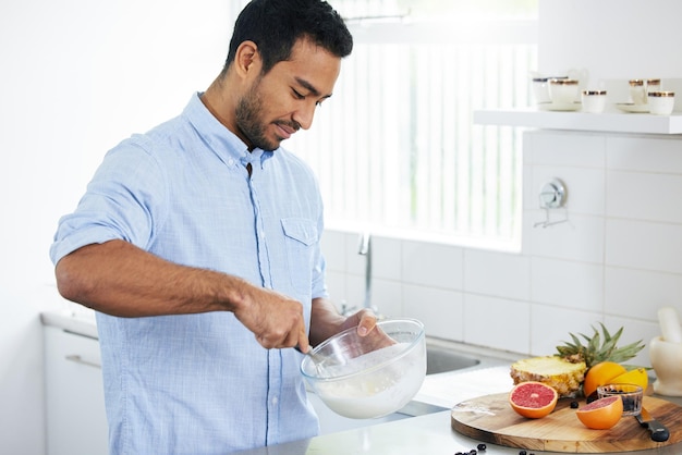 Estoy preparando algo delicioso y nutritivo Foto de un hombre preparándose un batido en casa