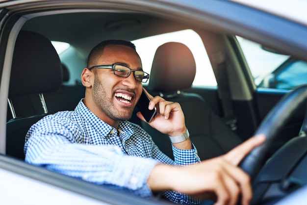 Estoy a la vuelta de la esquina Captura recortada de un joven hombre de negocios hablando por teléfono celular mientras conduce un automóvil