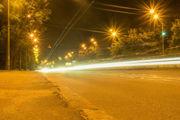 Estrada à noite com vestígios de faróis de carros