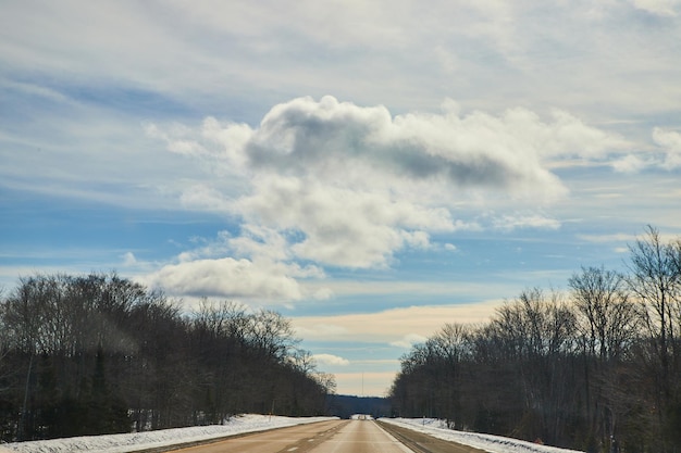 Estrada aberta de inverno com nuvens fofas e céu azul