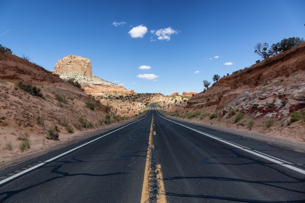 Estrada cênica no deserto seco com montanhas rochosas vermelhas ao fundo