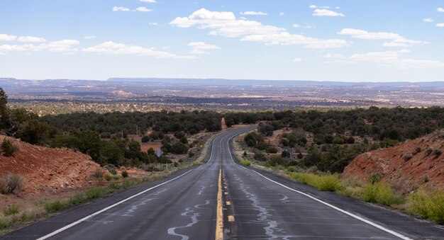 Foto estrada cênica no deserto seco com montanhas rochosas vermelhas ao fundo