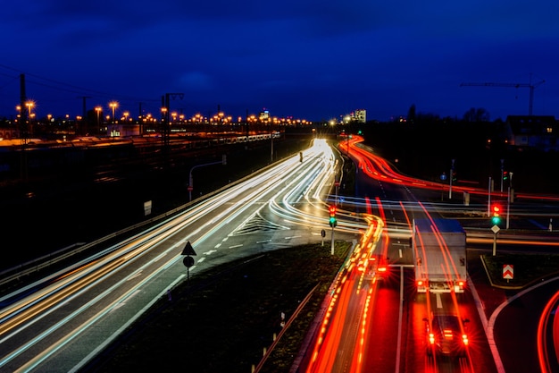 Estrada da cidade noturna na Alemanha com faixas de luz turva de carros