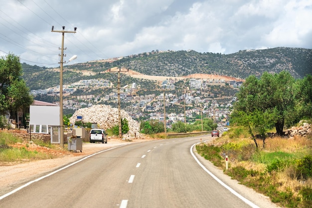 Estrada de asfalto com carro no fundo da cidade nas montanhas