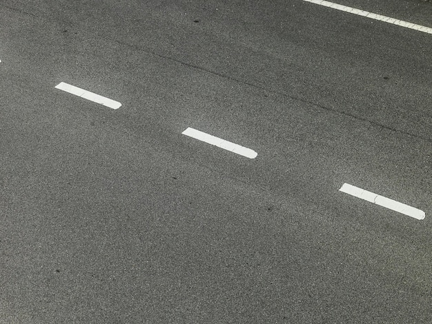 Estrada de asfalto com linhas de marcação textura de listras brancas fundo