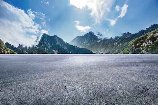 Estrada de asfalto com picos de montanha imponentes adequados para fundo de publicidade de carro