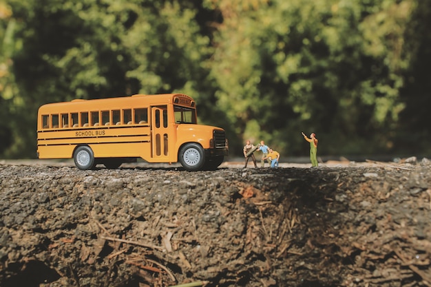 Estrada de asfalto rachada e obras rodoviárias com figuras em miniatura em um cenário do país.