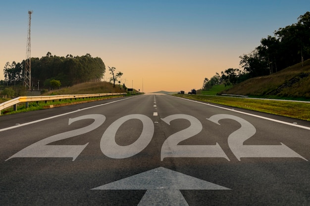 Foto estrada de asfalto vazia e conceito de ano novo 2022 dirigindo em uma estrada vazia para objetivos de 2022 com o pôr do sol