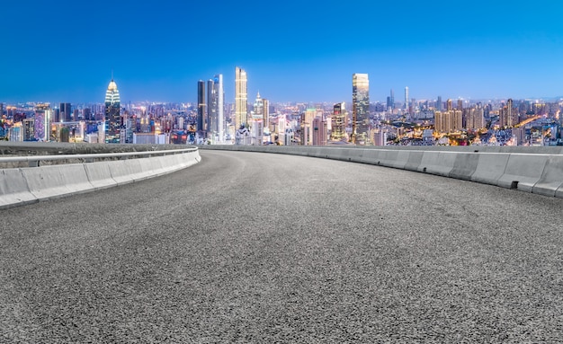 Estrada de asfalto vazia e o horizonte da cidade e a paisagem do edifício, china.