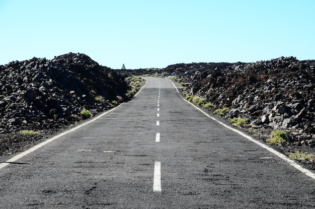 Estrada de asfalto vazia longa do deserto nas Ilhas Canárias, Espanha