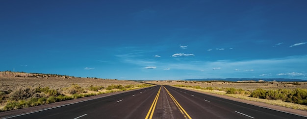 Foto estrada de asfalto vista lateral no dia ensolarado de verão monument valley road