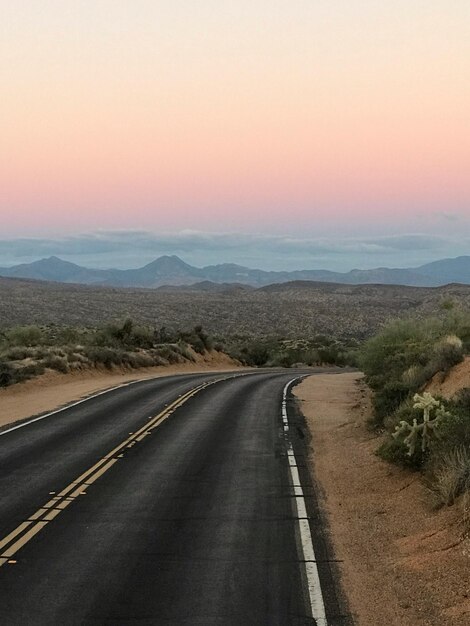 Foto estrada de campo contra o céu durante o pôr do sol