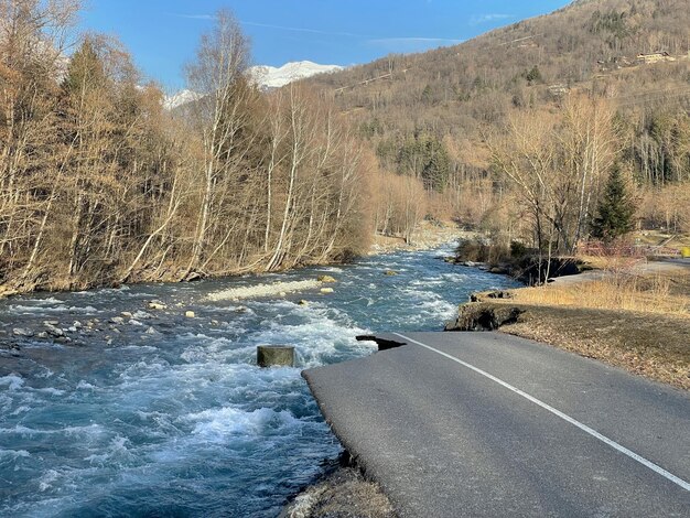 estrada de ciclismo na borda de um rio que flui em um vale alpino destruir durante uma inundação em Savoy