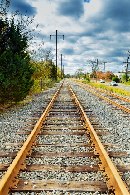 Foto estrada de ferro vazia no dia de outono com folhas caídas