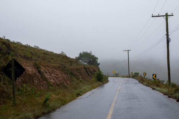 Estrada de mão dupla na área rural com árvores em dia de neblina sem carro