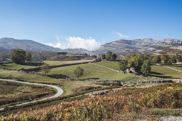 Estrada de montanha, com um céu claro e nuvens baixas