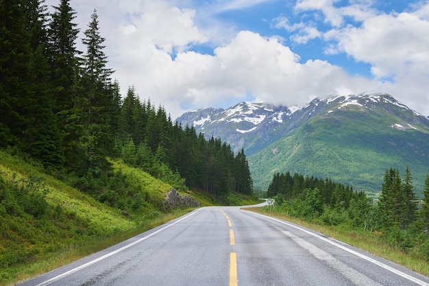 Estrada de montanha de estrada e ambiente rural com liberdade para viajar neve de verão no Alasca e rua ou aventura Paisagem de caminho de garagem calmo na natureza para transporte de férias