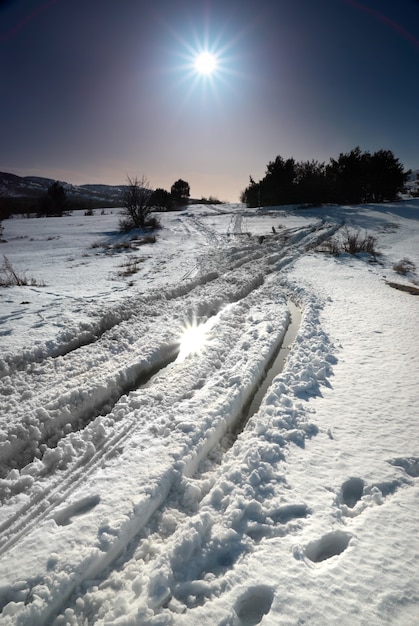 Foto estrada de neve de inverno com estrela do sol.