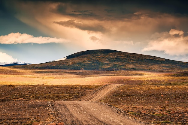 Estrada de terra através da montanha vulcânica no deserto remoto na cena rural