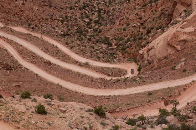 Estrada de terra cênica cercada por montanhas de rocha vermelha no canyon do deserto