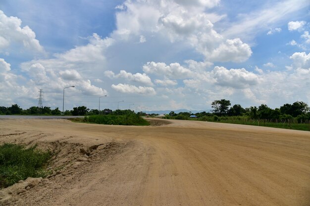 Estrada de terra em meio a um campo contra o céu