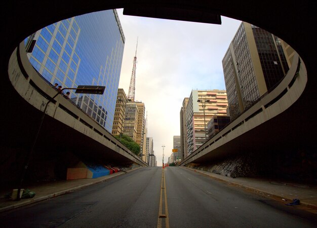 Foto estrada em meio a edifícios na cidade contra o céu