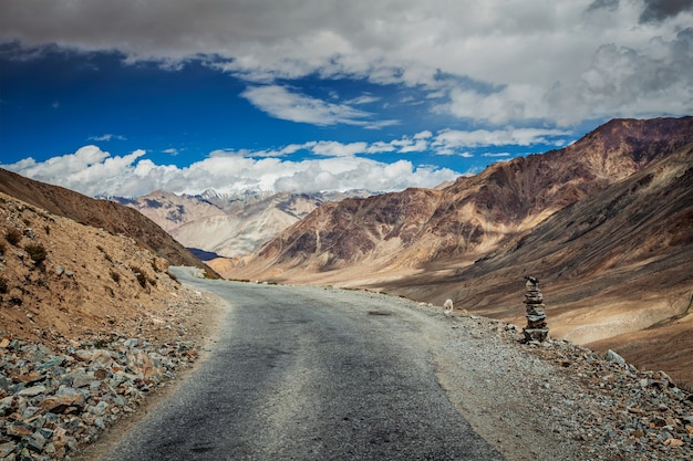 Estrada no Himalaia perto de Kardung La passa com um monte de pedras. Ladakh, Índia