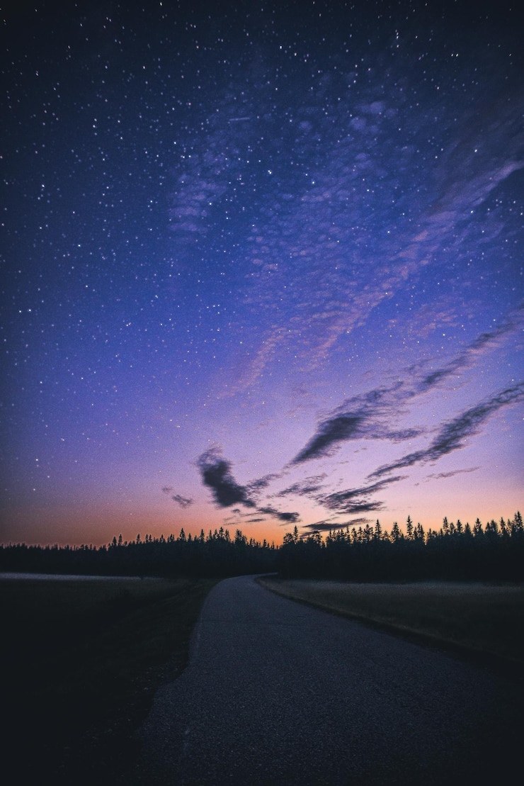 Foto estrada no meio da terra contra o campo de estrelas à noite