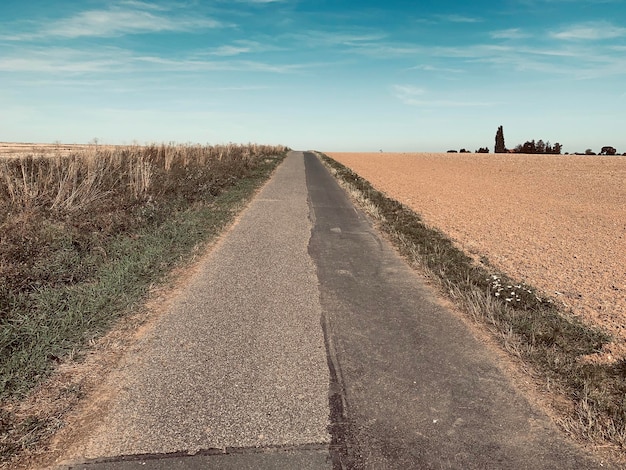 Foto estrada no meio do campo contra o céu