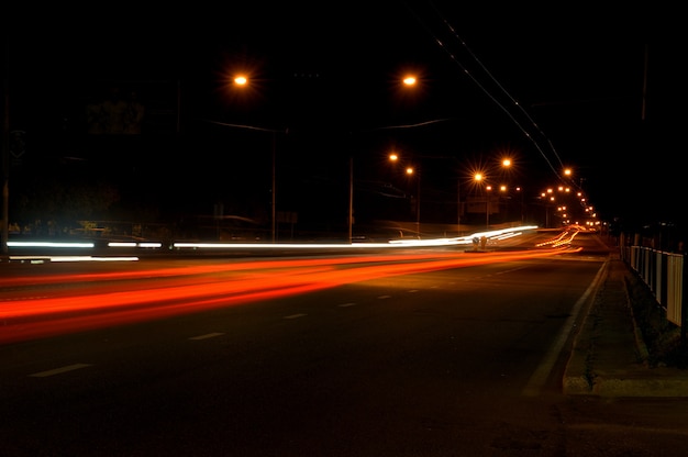 Estrada noturna na cidade com carro as trilhas leves