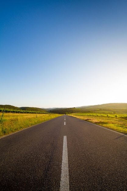 Estrada passando por um campo contra um céu claro