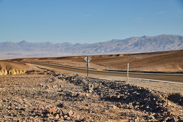 Estrada pavimentada deserta vazia por montanhas no Vale da Morte