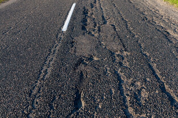 Estrada pavimentada para circulação de veículos diversos, estrada antiga com defeitos no asfalto