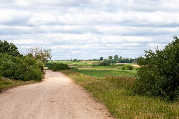 Estrada pavimentada vazia na zona rural sob a forma de uma pista das rodas dos carros