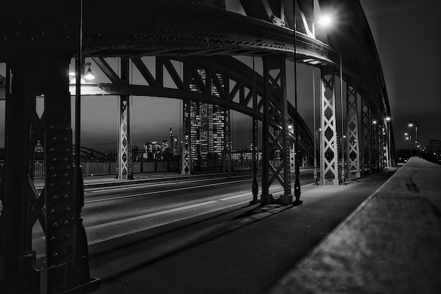 Foto estrada pela ponte iluminada na cidade contra o céu à noite